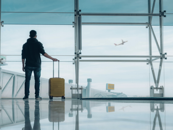 Person stood alone in empty airport with suitcase