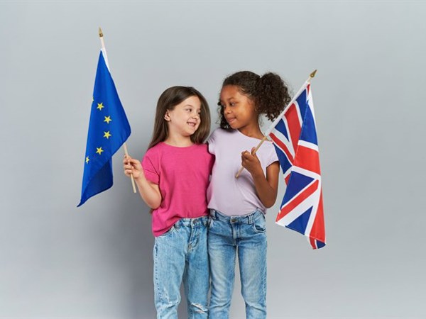 Girls Embracing Holding British European Union Flags